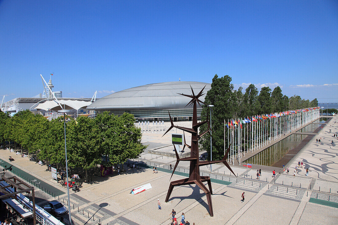 Portugal,Lisbon,Parque das Nacoes,Atlantic Pavilion,Grand Esplanade,flags,Sun Man statue by Jorge Vieira,Vasco da Gama shoppping mall (arch Jose Quintela)