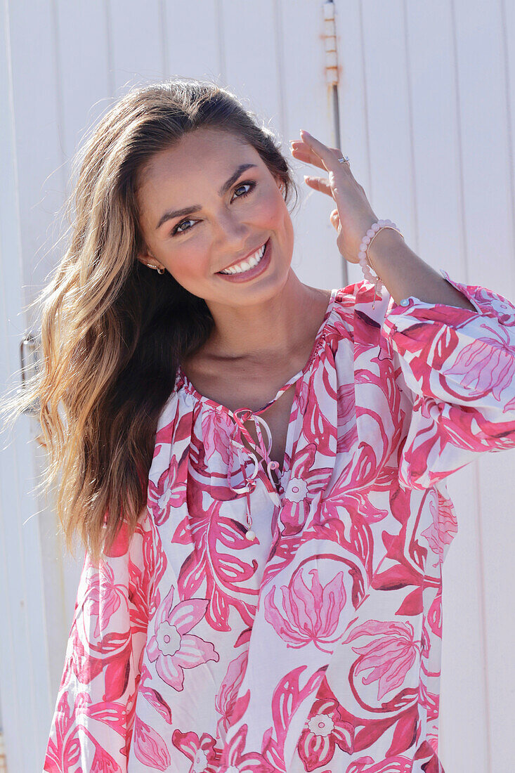 Woman in floral tunic on the beach