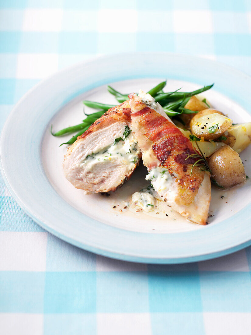 Stuffed chicken wrapped in bacon with vegetables