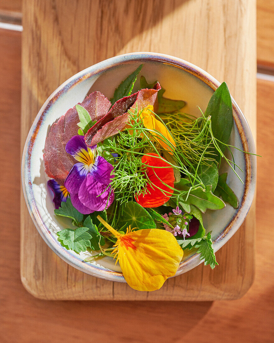 Salad with edible flowers and fresh herbs