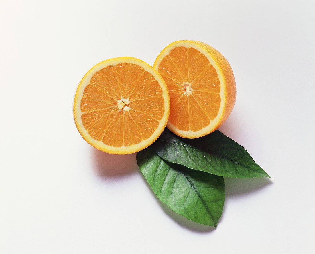 Halbierte Orange und zwei Blätter