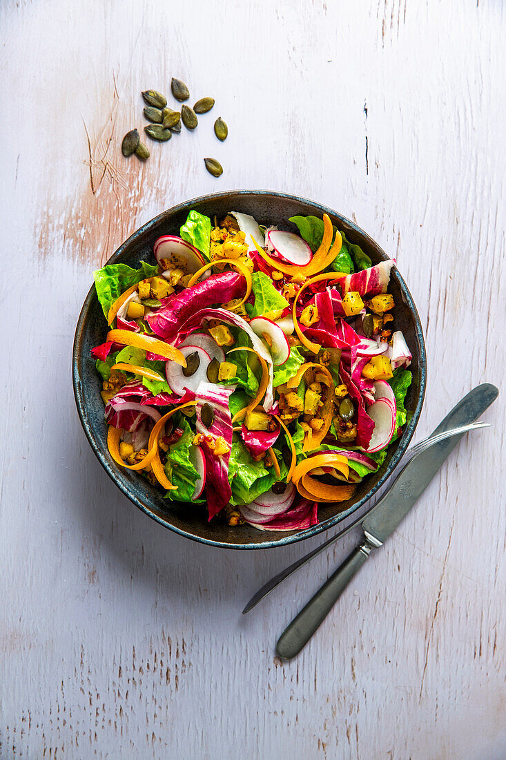 Autumn salad with colourful vegetables and pumpkin seeds