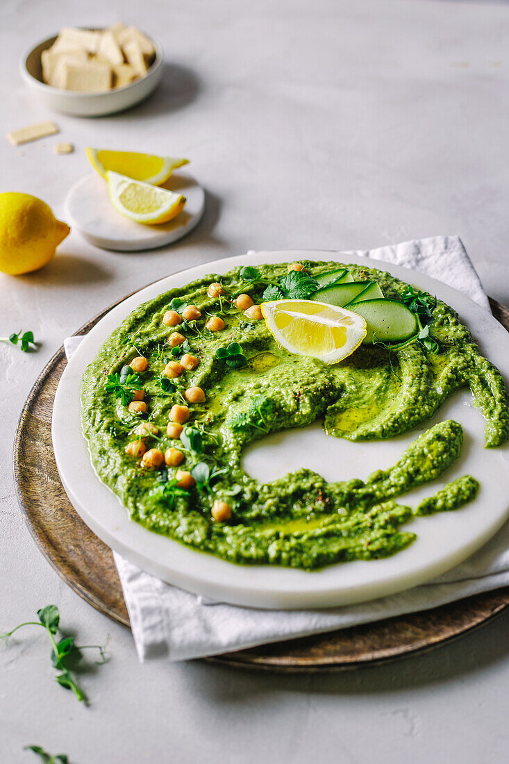 Herb hummus with lemon wedges and crackers