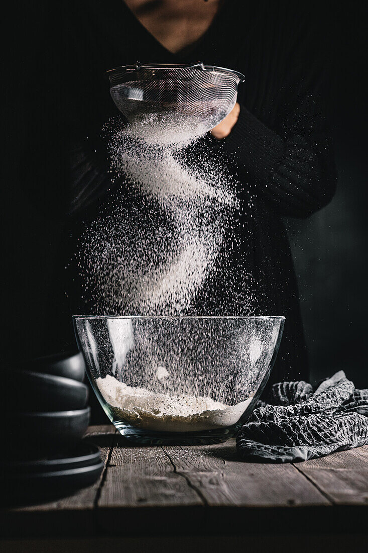 Sifting flour into a glass bowl