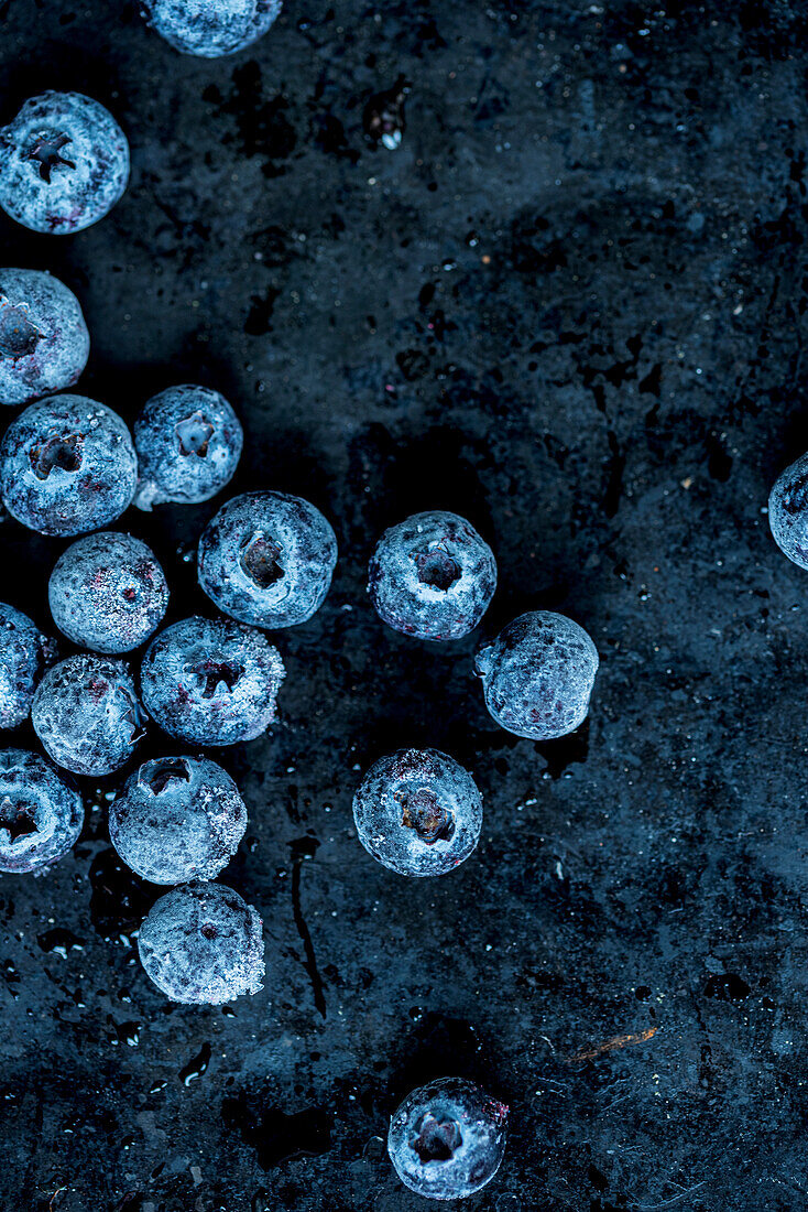 Gefrorene Blaubeeren auf dunklem Untergrund