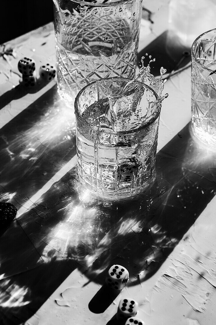 Splashing cocktail with ice cubes in black and white