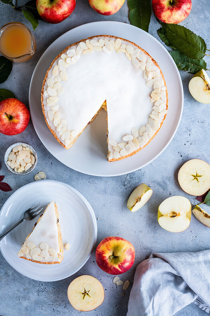 Gedeckter Apfelkuchen mit Zuckerglasur und Mandeln