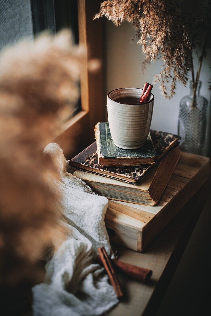 Cinnamon tea in a ceramic mug on books