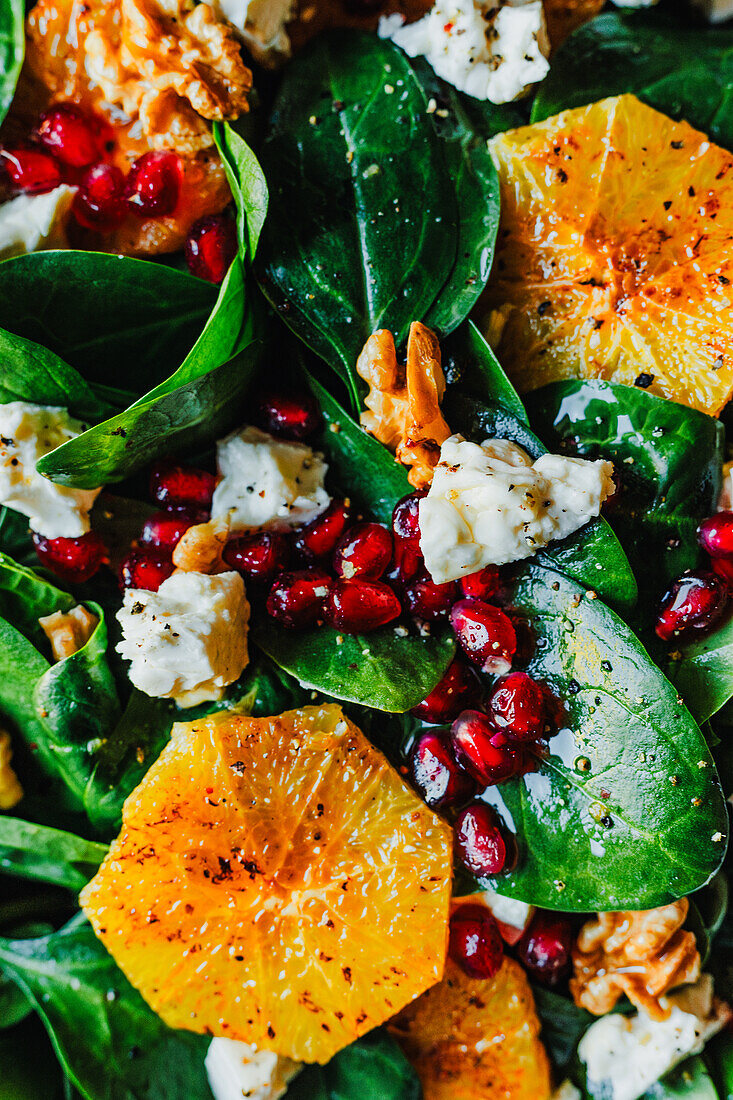 Spinach and orange salad with cheese, walnuts and pomegranate seeds