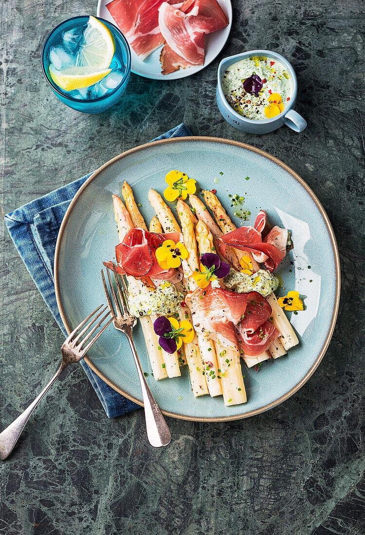 Asparagus from the tray with ham and green sauce