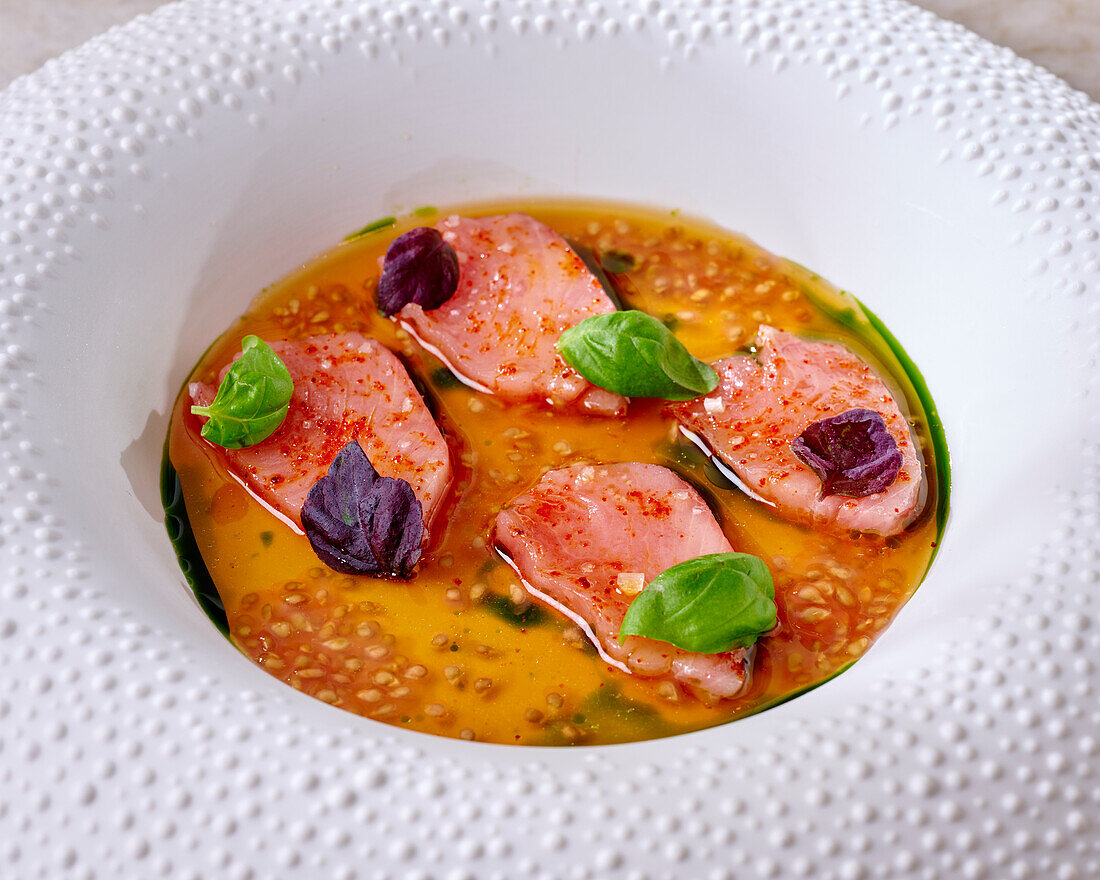 Bonito sashimi in tomato consommé with basil oil