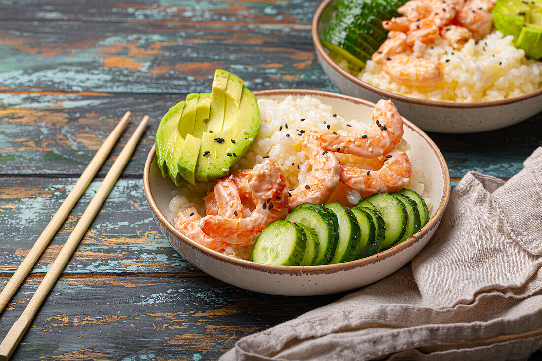 Poke Bowl mit Reis, Garnelen, Avocado und Gurke