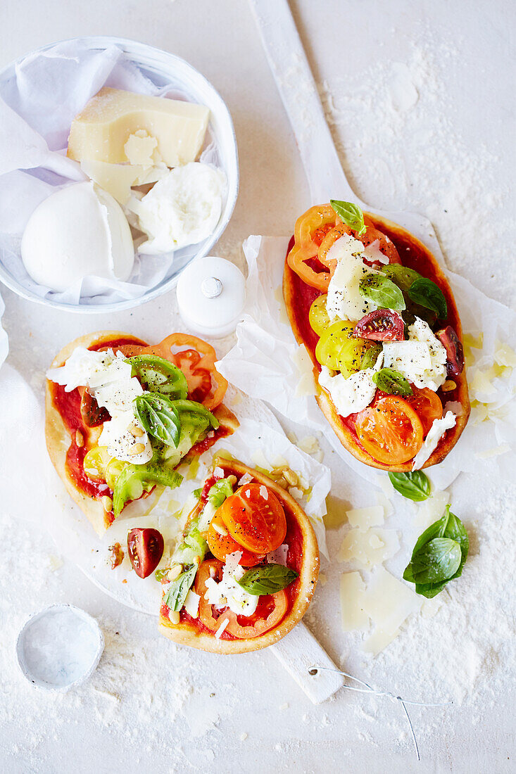 Minipizzen mit bunten Tomaten und Mozzarella