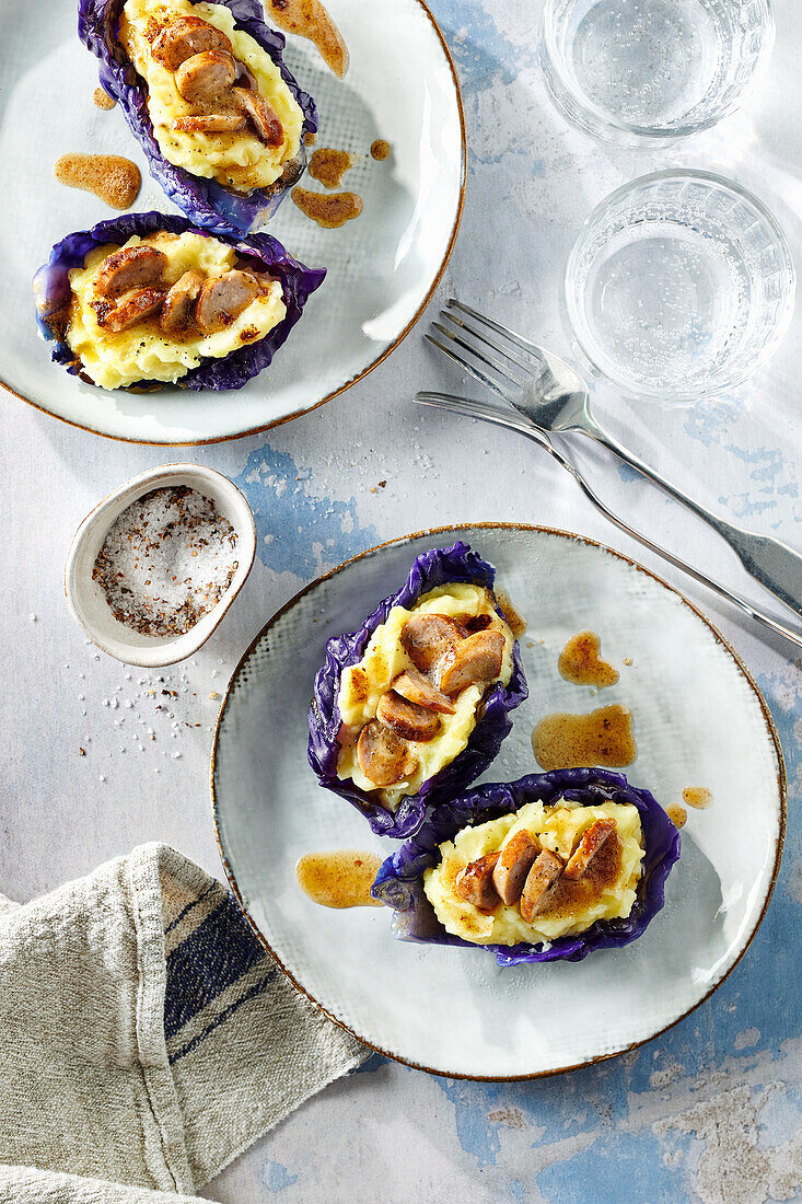 Red cabbage boat with mashed potato and sausage