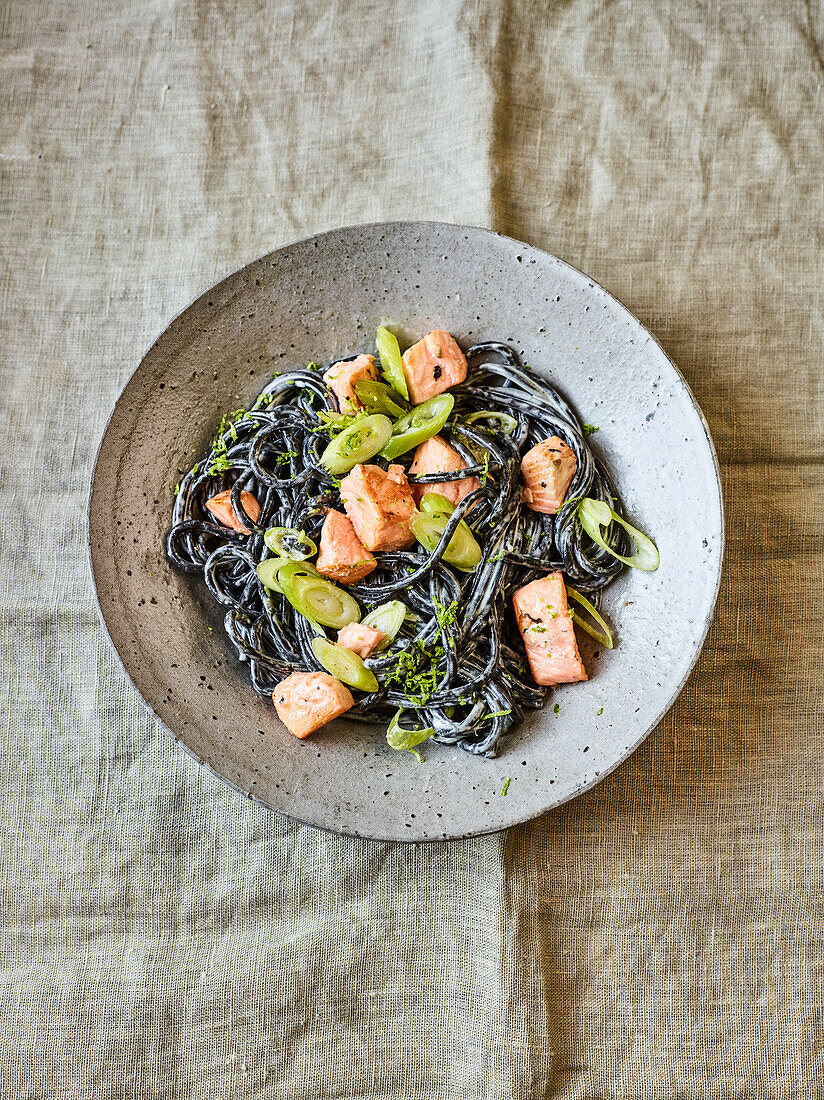 Black spaghetti salad with salmon and spring onions