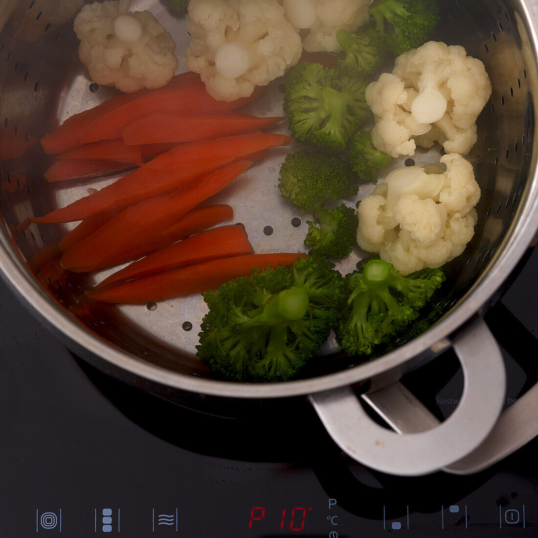 Carrots, cauliflower, broccoli in a steamer insert