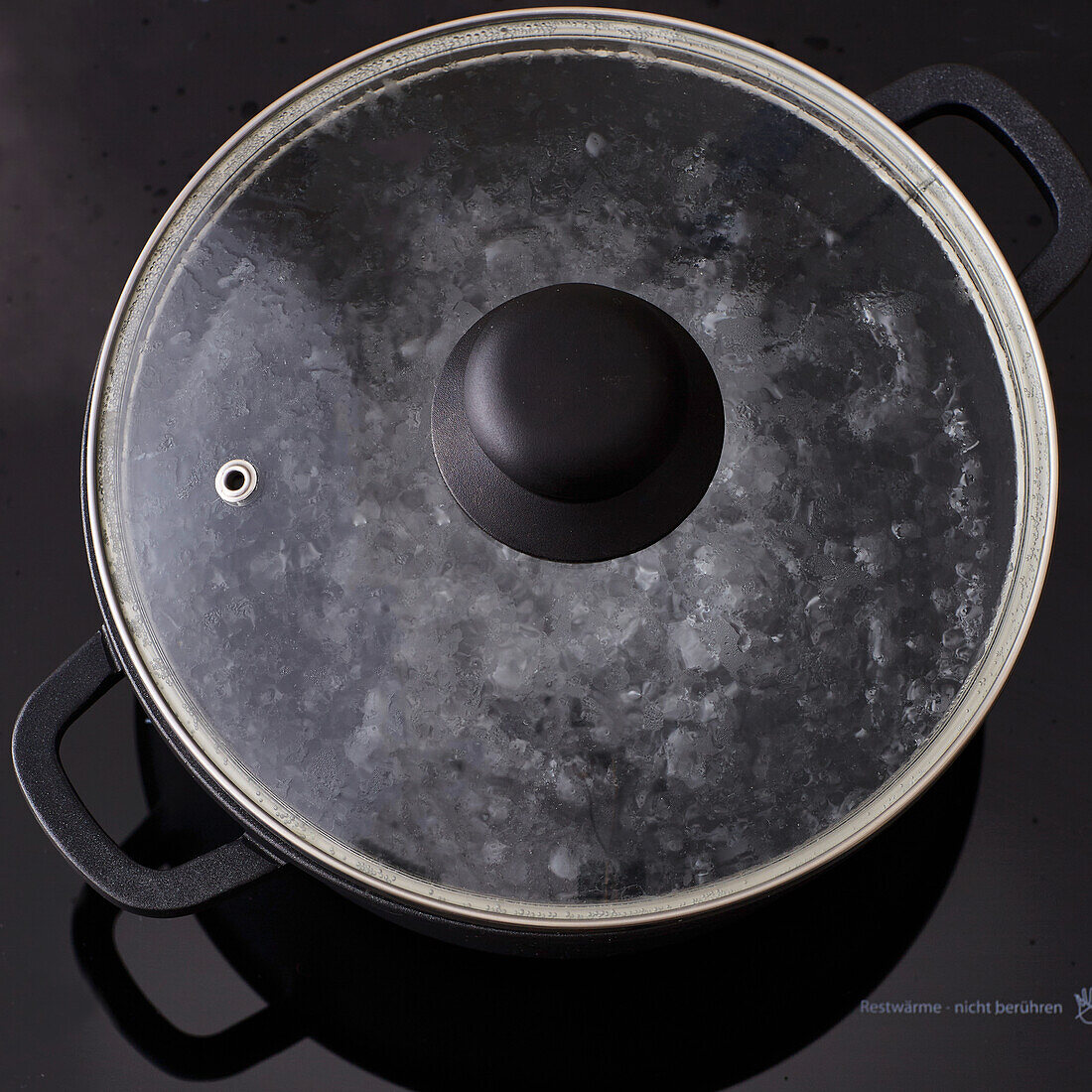 Saucepan with glass lid on the hob