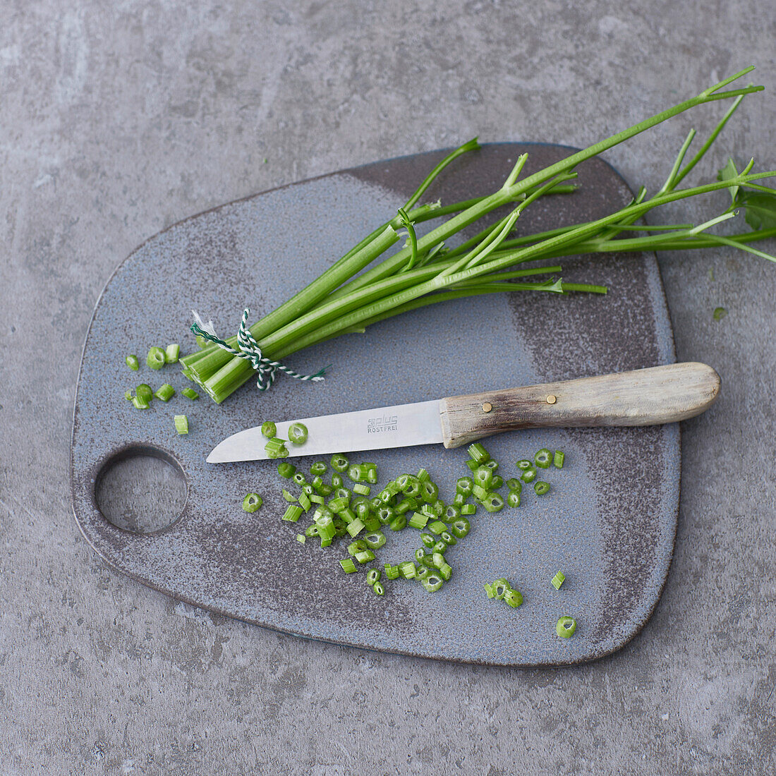 Chopped herb stalks on a chopping board