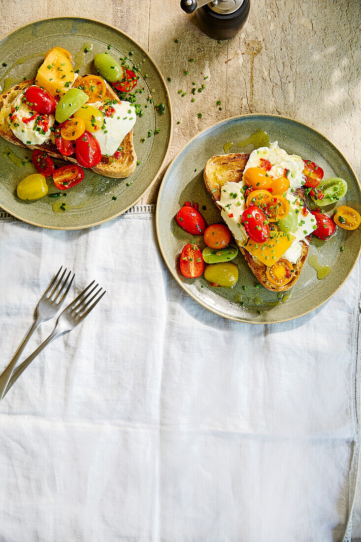 Geröstetes Brot mit Mozzarella und bunten Kirschtomaten