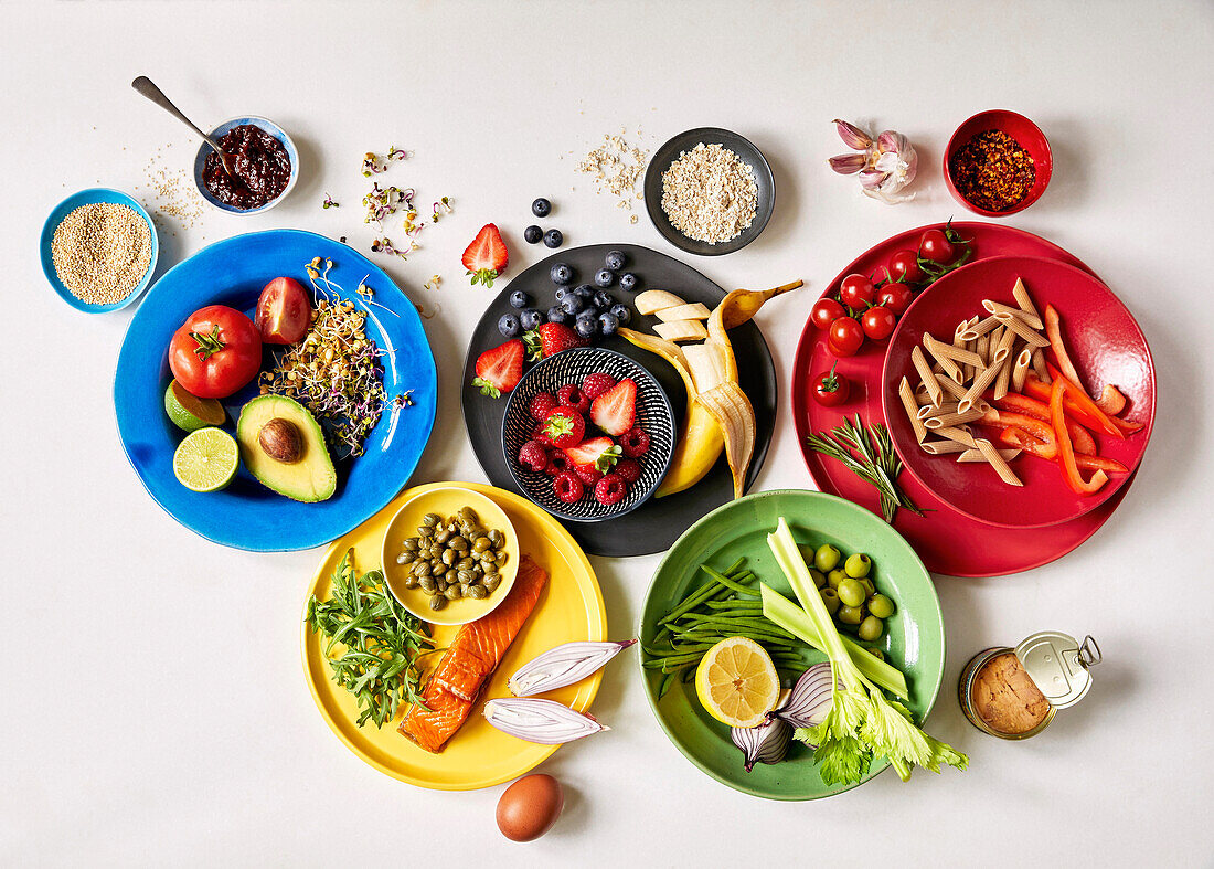 Verschiedene frische Zutaten wie Obst, Gemüse, Lachs und Pasta