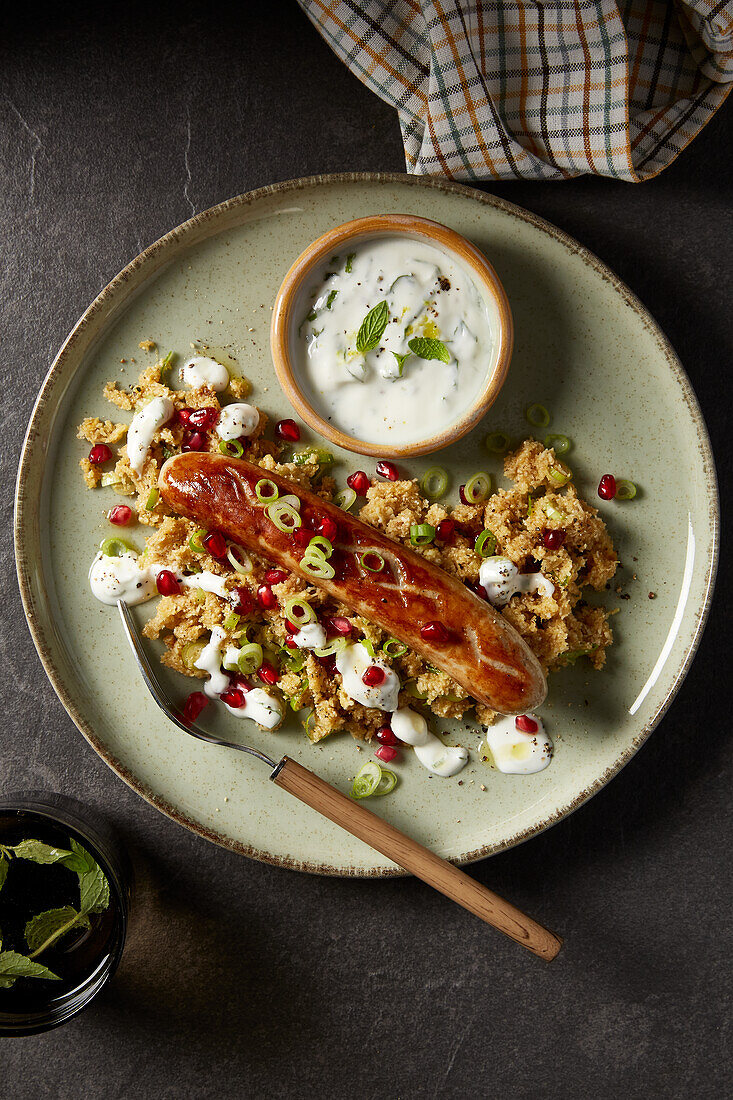 Bratwurst on cauliflower couscous with yogurt dip