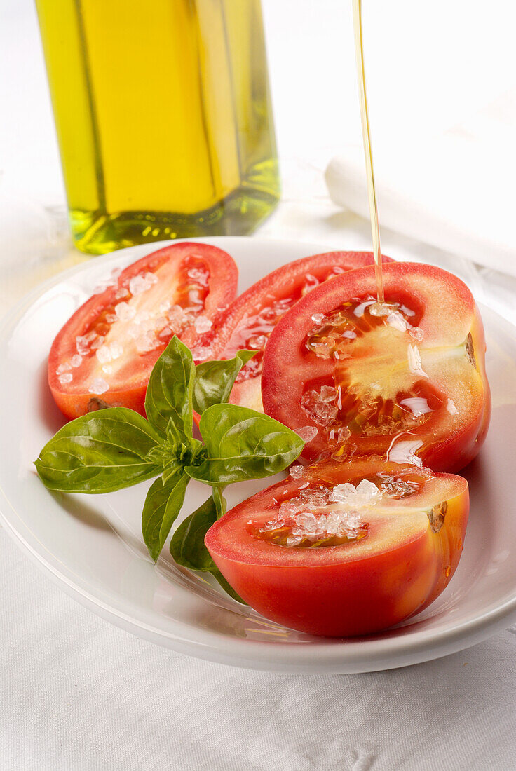 Halbierte Tomaten mit Meersalz und Olivenöl