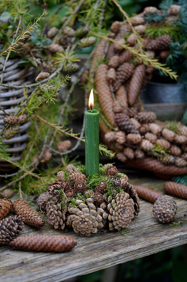 Candle holder made from various cones with a green candle