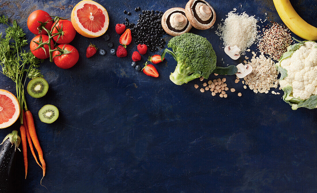 Various fresh fruit and vegetables on a dark blue background