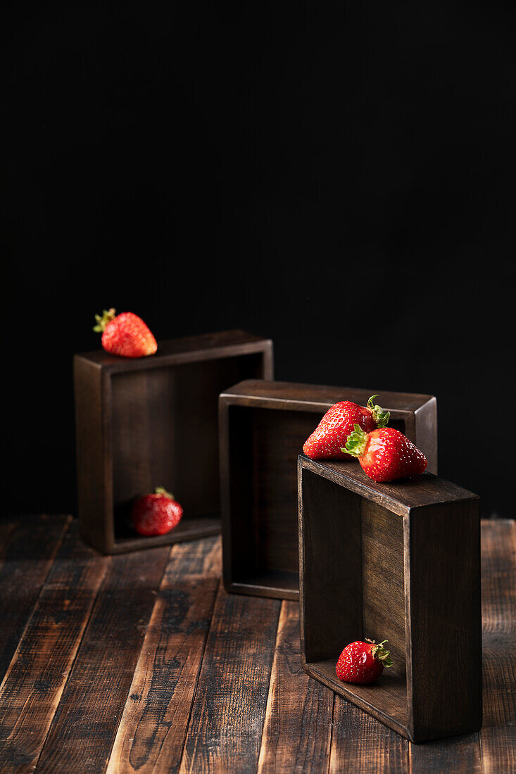 Erdbeeren arrangiert auf dunklen Holzkisten