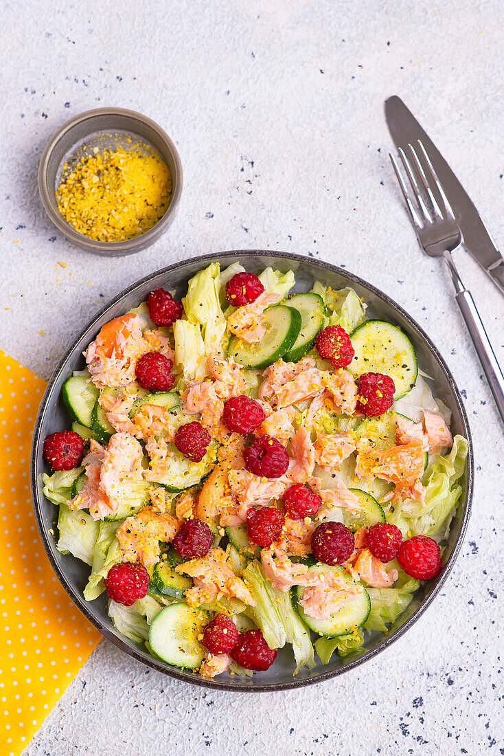 Iceberg lettuce with salmon, cucumber, raspberries and lemon pepper