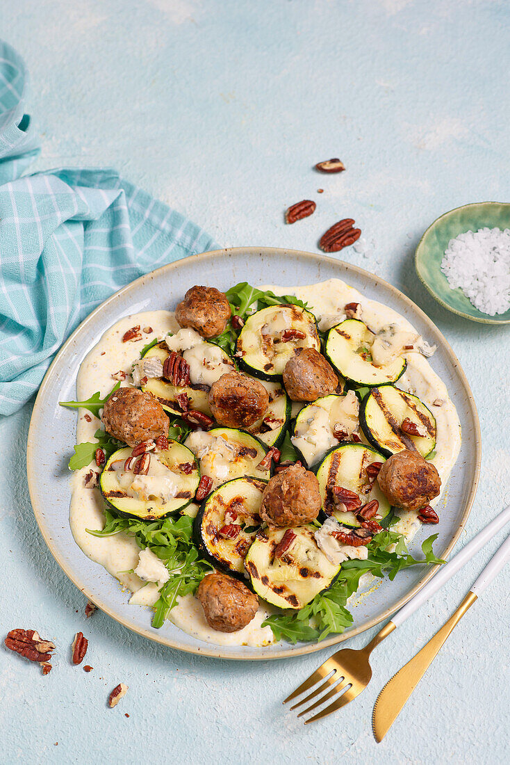 Grilled courgette with meatballs and lemon yoghurt on rocket