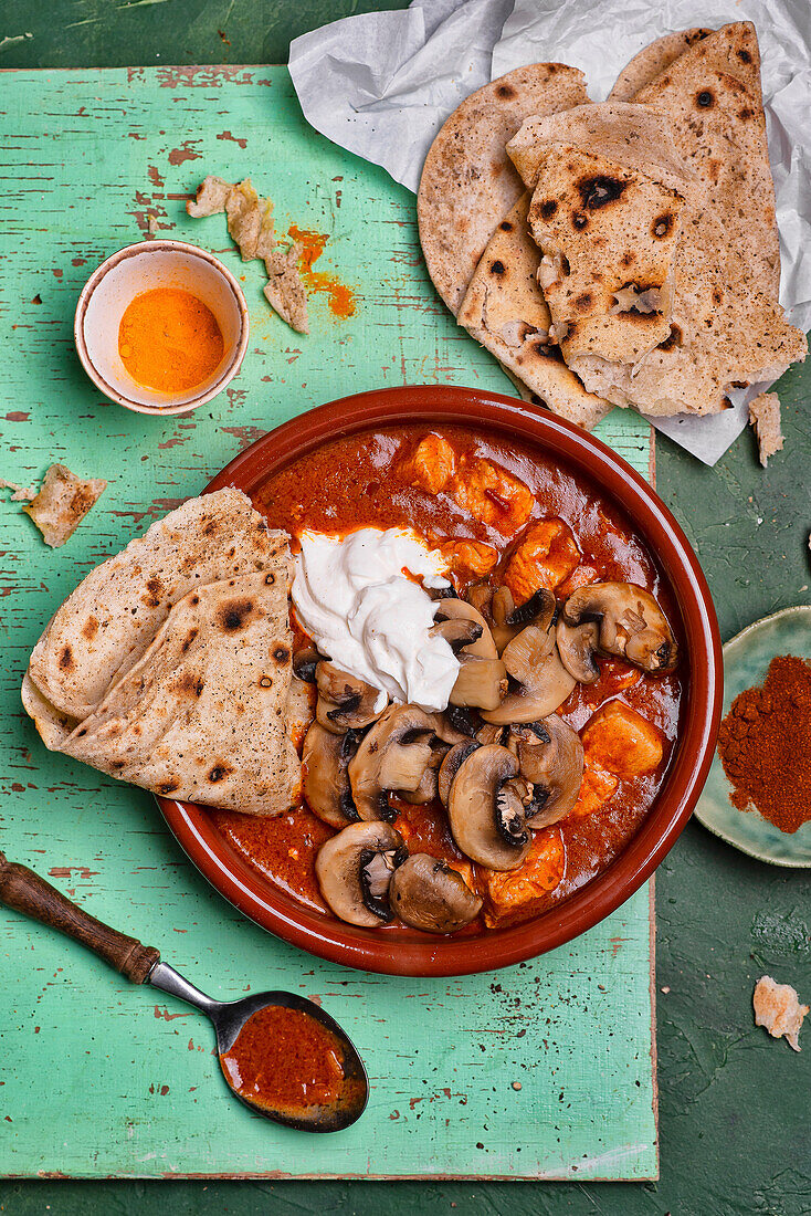 Chicken curry with mushrooms and yoghurt, served with naan bread