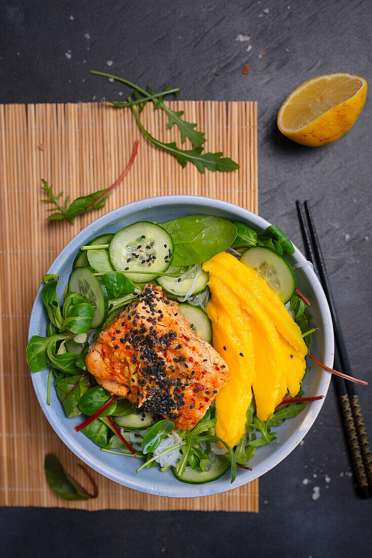 Salad with rice noodles, cucumber, mango and salmon