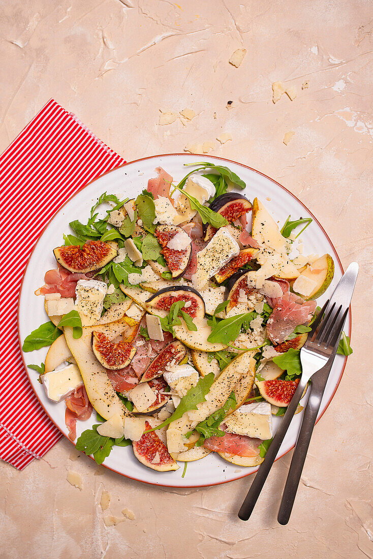 Salad with pears, figs, camembert, rocket, parmesan and Italian ham