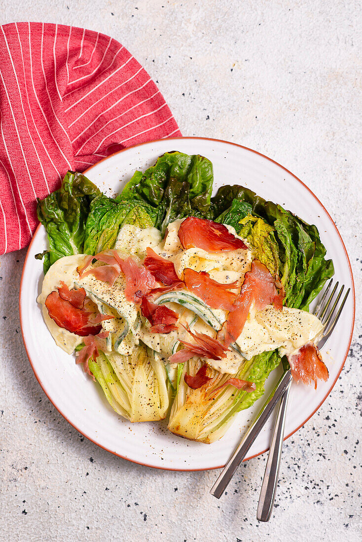 Roasted romaine lettuce with lemon dip and strips of ham