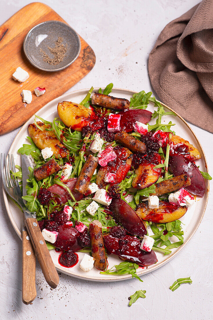 Rocket salad with feta, plum sauce and sausages