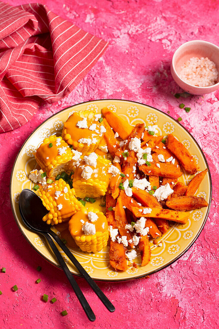 Süßkartoffelpommes mit Mais, Erdnusssauce und Feta