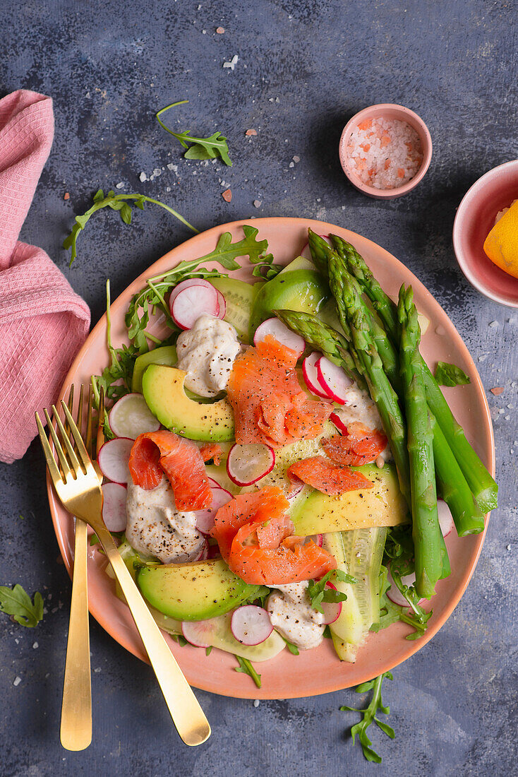 Salat mit Lachs, Avocado, Gurke, Radieschen und grünem Spargel