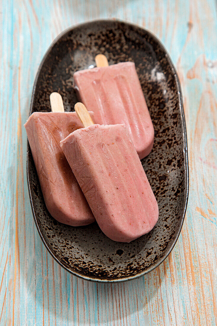 Strawberry and banana ice cream on a stick