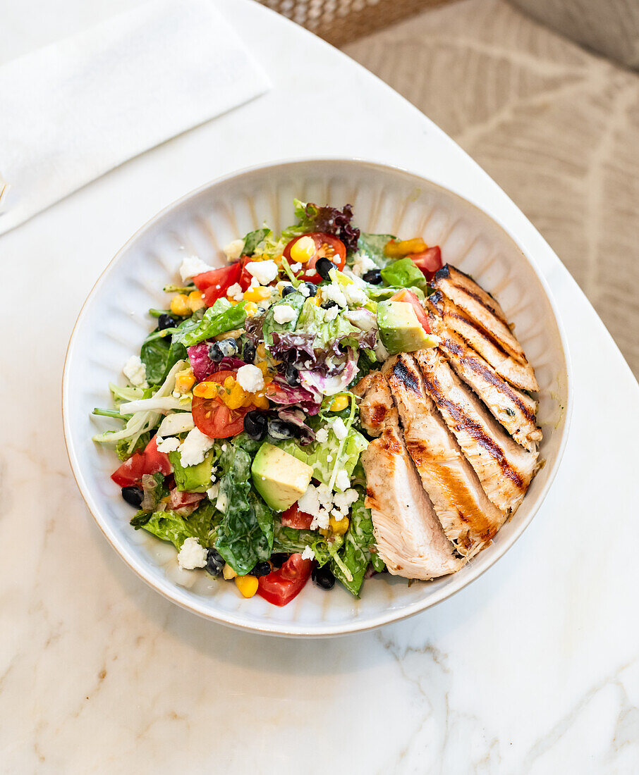 Salad with avocado, tomatoes, sweetcorn and chicken