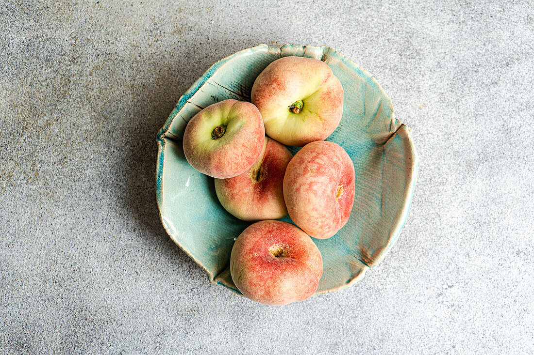 Flat peaches in a ceramic bowl