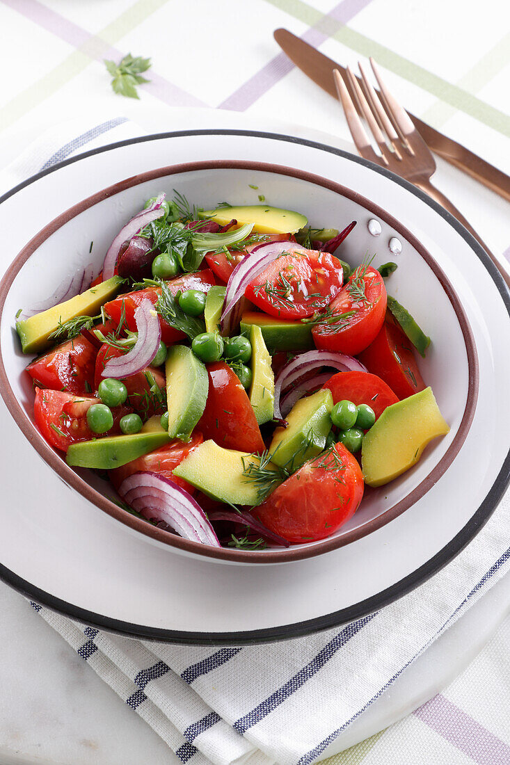 Salad with tomatoes, avocado, peas and onions