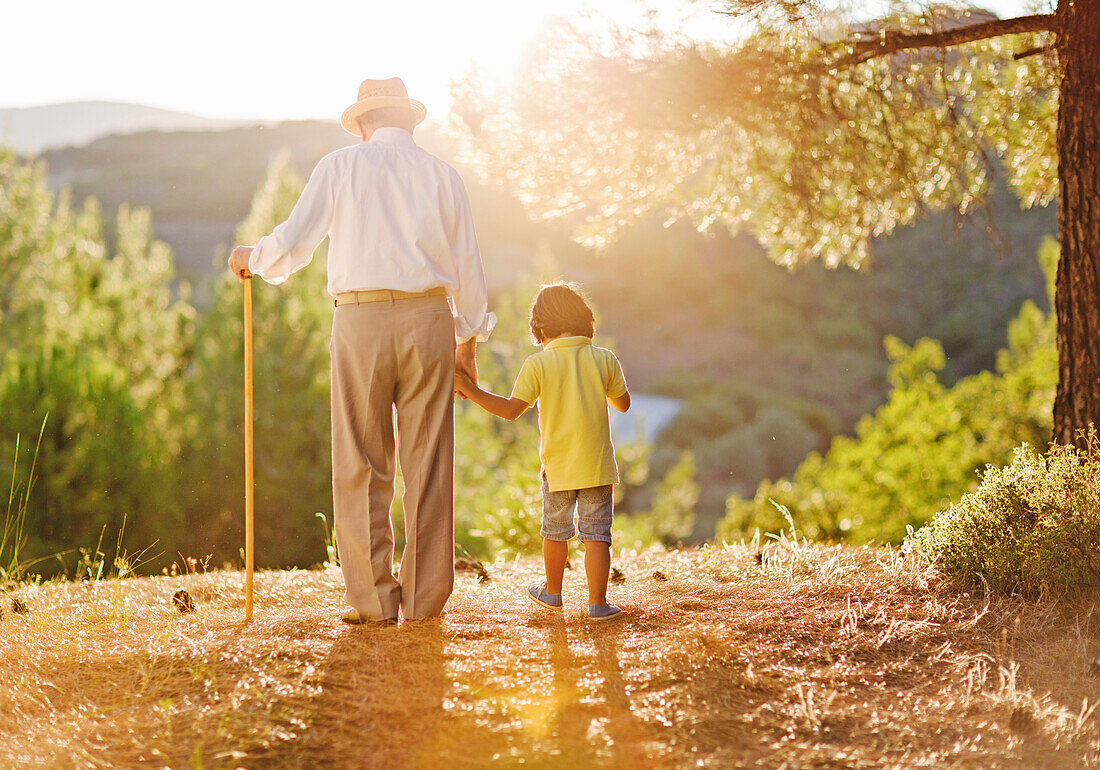 Senior walks with his grandson in the evening sun