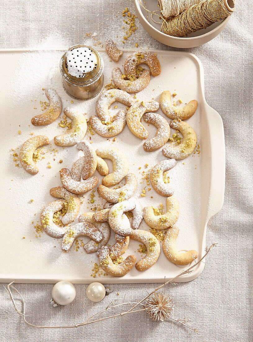 Vanilla crescents with icing sugar and chopped pistachios