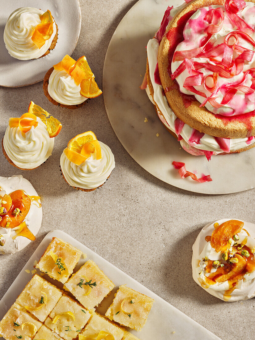 Lemon sponge cake, rhubarb tart and cupcakes with whipped cream topping