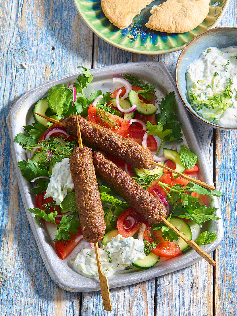 Grilled beef kebabs with tzatziki and salad