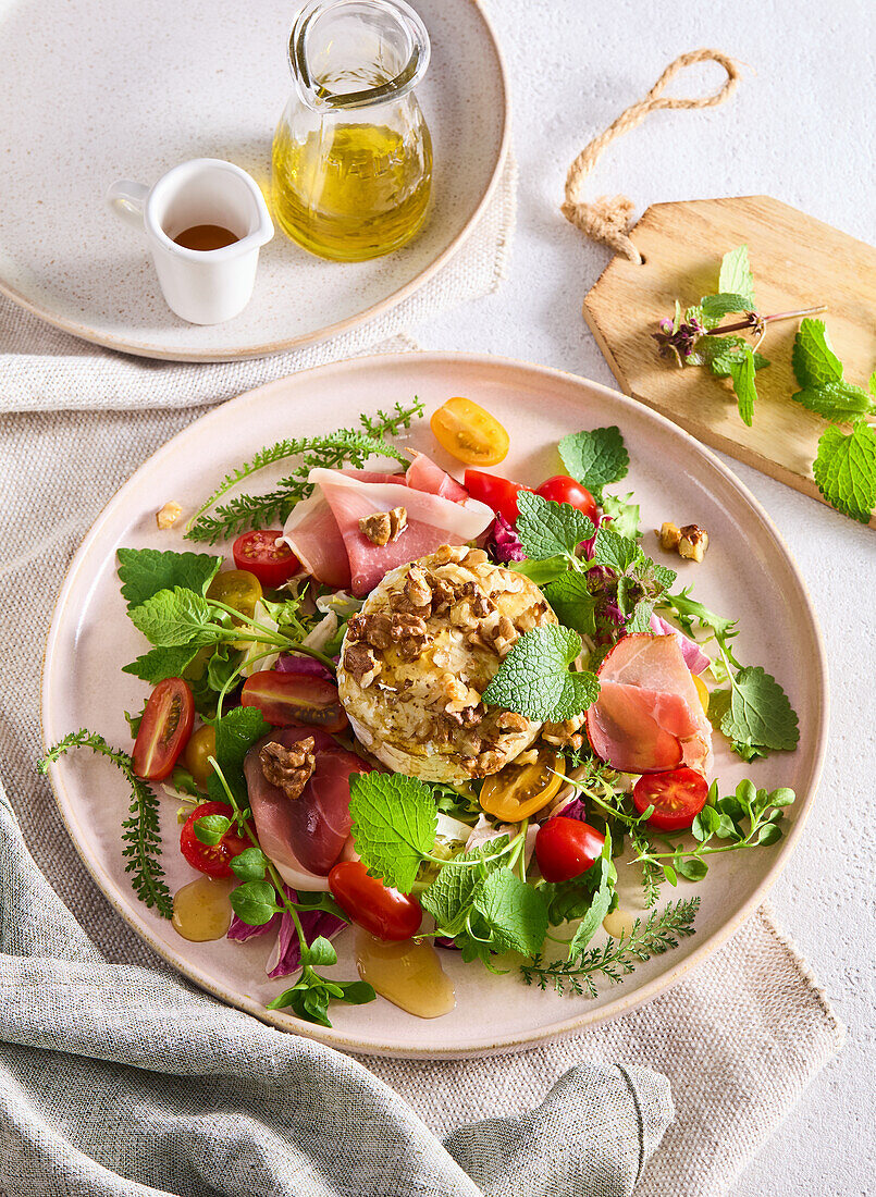 Spring salad with herbs, grilled camembert and ham