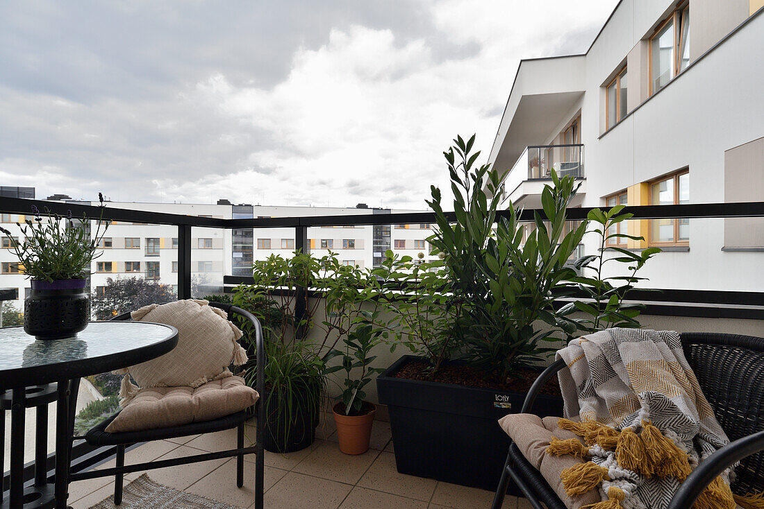 Cosy balcony with plants and seating in a modern apartment complex