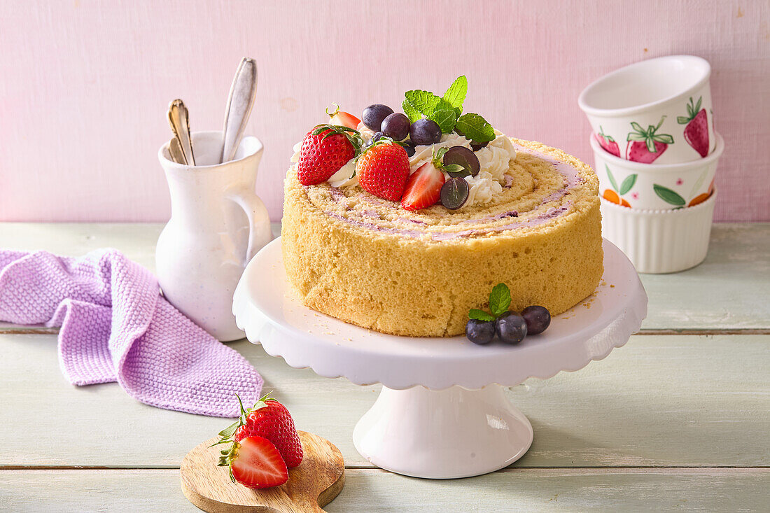 Sponge roll cake with strawberries, grapes and cream filling