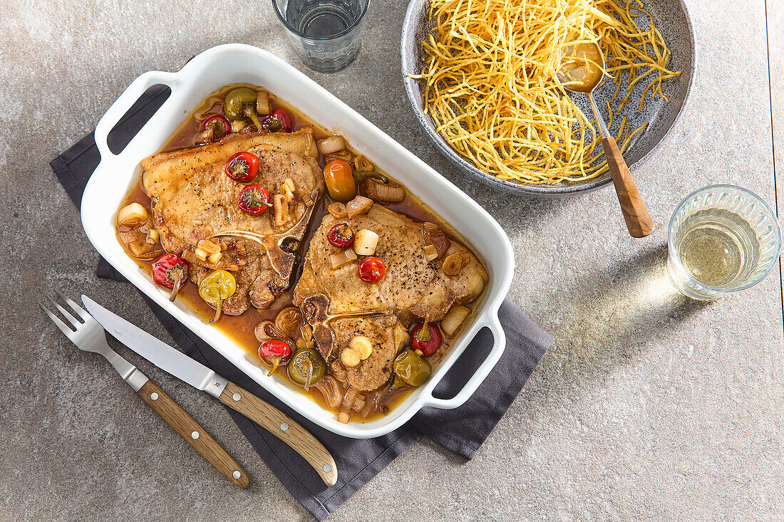 Schweinekoteletts mit eingelegten Paprika und Kartoffelstroh